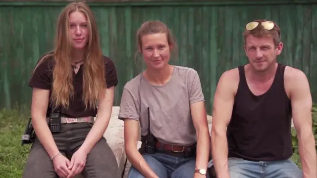 Three aid workers sit side-by-side