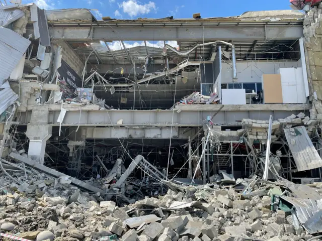 Debris from a shelled shopping centre is photographed in Kharkiv