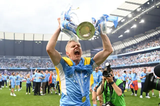 Ukrainian footballer Oleksandr Zinchenko, of Manchester City, celebrates winning the Premier League with a Ukrainian flag draped around him