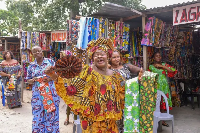 Woman dancing outside wearing traditional African attire