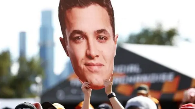 A fan holds up a Lando Norris giant head