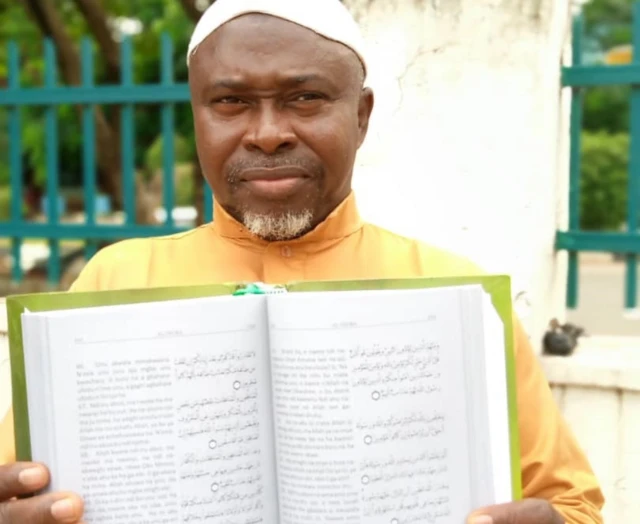 Muhammad Murtala Chukwuemeka holding the Igbo translation of the Quran