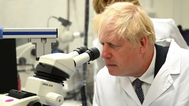 Boris Johnson looking down a microscope at the Francis Crick Institute in London