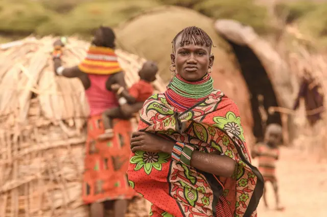 Person in traditional attire standing with their arms folded