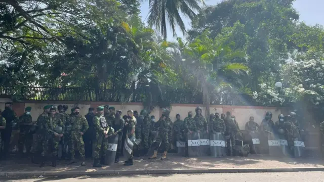 Police men line up against a wall