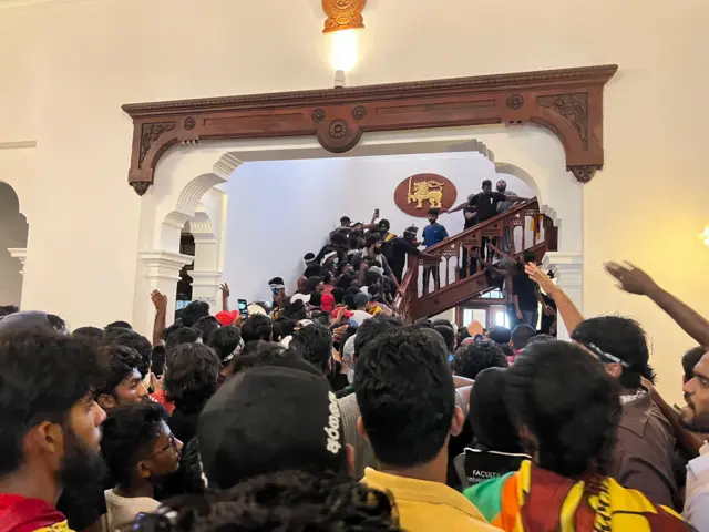 Protesters swarm up the stairs inside the prime minister's office