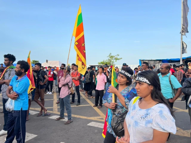 Protesters wearing Gota Go Home signs and carrying the Sri Lankan flag at Galle Face Green