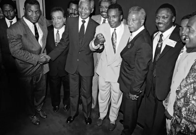 Nelson Mandela flanked by Mike Tyson (L) and Sugar Ray Leonard (R) in June 1990 in New York