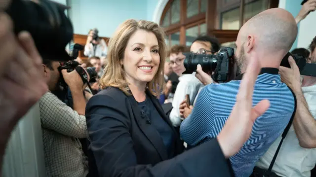 Penny Mordaunt smiles as she is surrounded by press as she launches her leadership bid