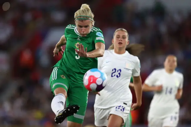 Northern Ireland's defender Julie Nelson (L) kicks the ball next to England's striker Alessia Russo during the UEFA Women's Euro 2022 Group A football match between Northern Ireland and England at St Mary's Stadium