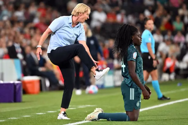 Germany's head coach Martina Voss-Tecklenburg reacts next to Germany's midfielder Nicole Anyomi during the UEFA Women's Euro 2022 Group B football match between Finland and Germany at Stadium MK in Milton Keynes