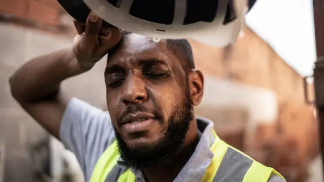 A man wiping sweat from his forehead