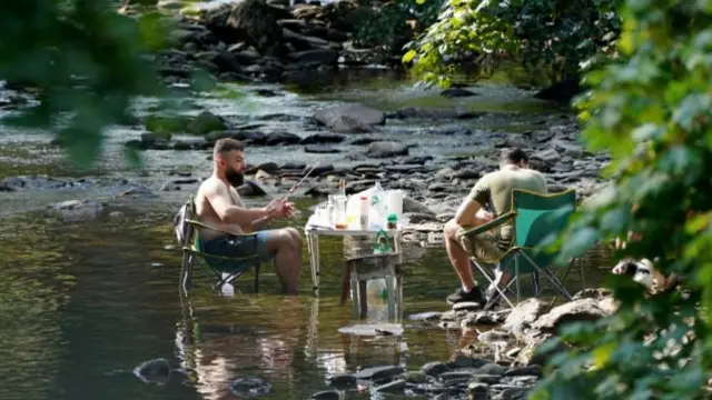 People enjoy a barbecue in a river near the village of Luss in Argyll and Bute, Scotland, on the west bank of Loch Lomond