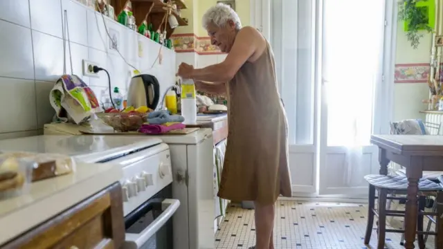 A woman stands in her kitchen during the heatwave