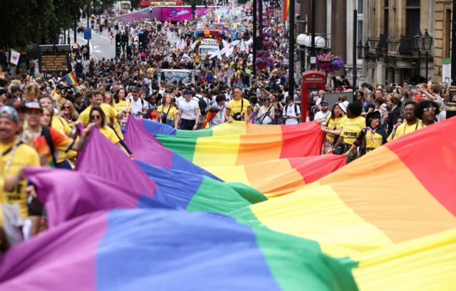 People carry a large rainbow flag, as they take part in the 2022 Pride Parade in London