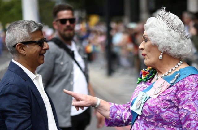 London Mayor Sadiq Khan talks to a person dressed as a queen