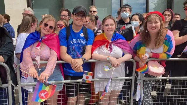 Four friends wearing Pride flags