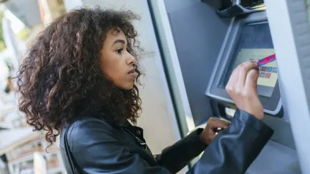 A woman uses a cash machine