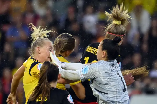 Nicky Evrard (R) hits Sweden's striker Stina Blackstenius (L) during the UEFA Women's Euro 2022 quarter final football match between Sweden and Belgium at the Leigh Sports Village Stadium, in Leigh, on July 22, 2022