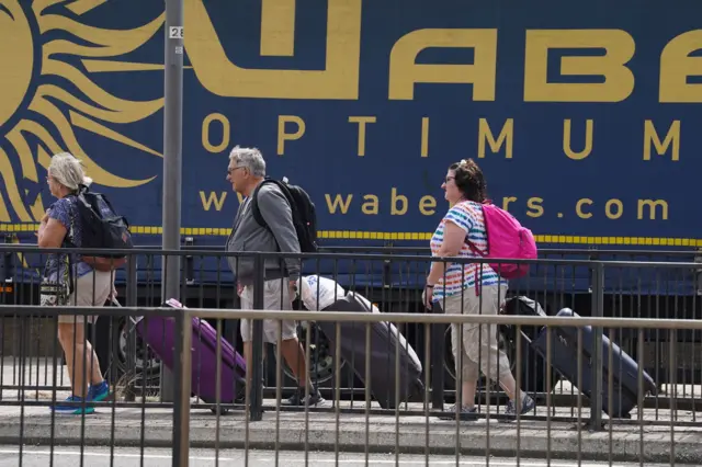 People make their way to the cruise terminal in Dover in Kent as no taxis or buses are available due to the traffic jams