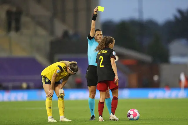 Davina Philtjens of Belgium is shown a yellow card by referee Kateryna Monzul during the UEFA Women's Euro 2022 Quarter Final match between Sweden and Belgium at Leigh Sports Village