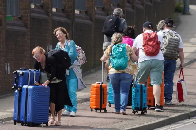 People make their way to the cruise terminal in Dover in Kent as no taxis or buses are available due to the traffic jams