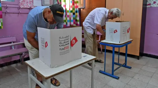 Tunisians vote in a referendum on a draft constitution put forward by the country's president, at a polling station