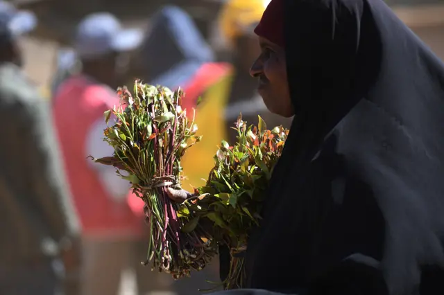 Khat trader carrying shoots for transportation at an open air market in Maua, in Meru county on May 31, 2022.