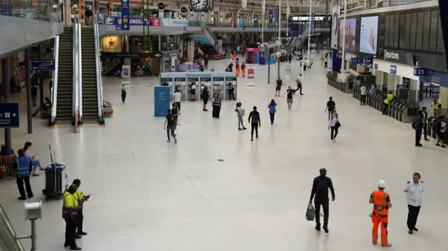 People walk at an almost empty London Waterloo station