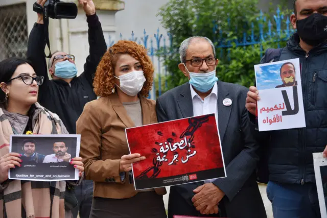 Members of the Tunisian Journalists Union pose with posters in support of imprisoned Moroccan journalists Omar Radi and Souleimane Raissouni, on the occasion of World Press Freedom Day.