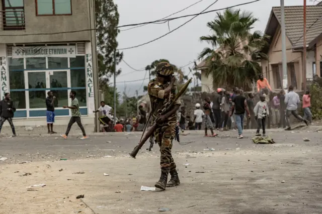 A Congolese soldier covers his face to protect himself from tear gas fired in Goma on July 26, 2022 during a protest against the UN peacekeeping mission MONUSCO