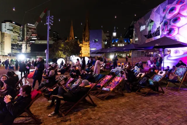 Neighbours fans watch an outside screen of the final episode in Melbourne on Thursday evening