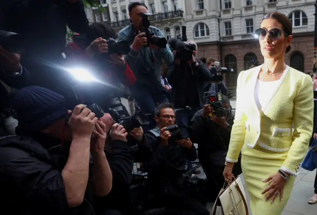 Rebekah Vardy arriving at the Royal Courts of Justice in May next to a crowd of photographers taking pictures