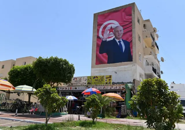 A billboard depicting Tunisia's Kais Saied hangs on the side of a building in the east-central city of Kairouan, on July 26, 2022