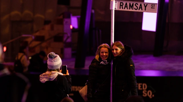 People are seen during a screening of the finale of TV show Neighbours at Federation Square in Melbourne, Australia, 28 July, 2022