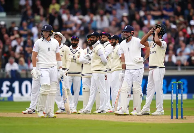 England and India players watch for a review for a catch against Matthew Potts