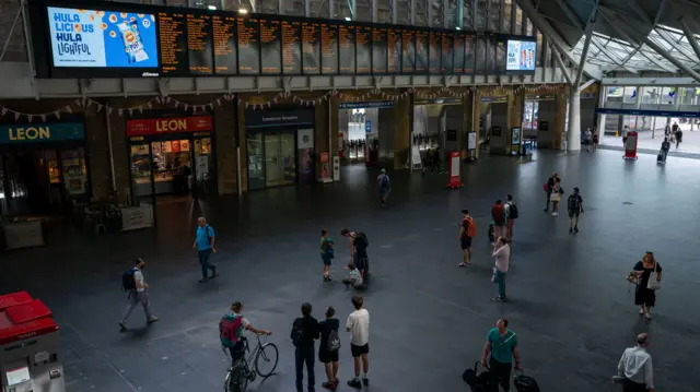 Passengers check the boards at London's King's Cross Station