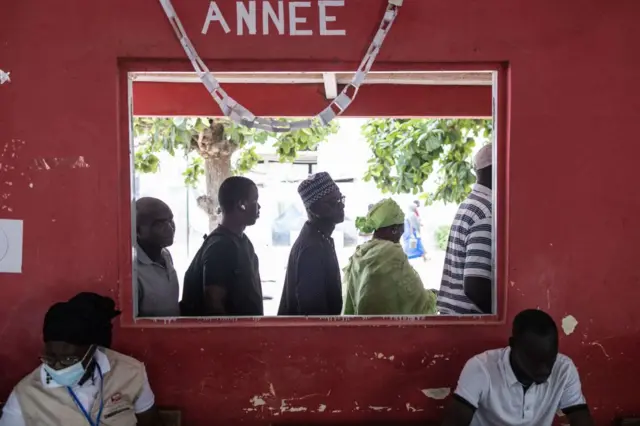 People wait in line outside their voting station in the popular neighbourhood of Ngor in Dakar, Senegal - 31 July 2022