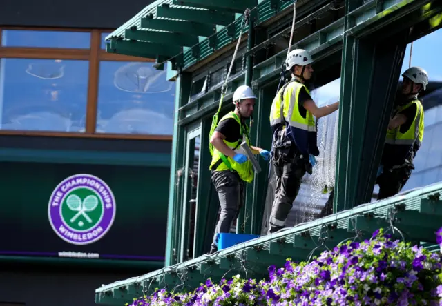 Window cleaners work around the course ahead of day eight of the 2022 Wimbledon Championships at the All England Lawn Tennis and Croquet Club