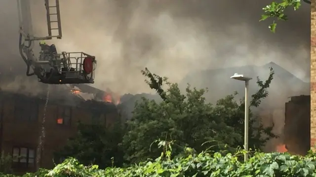 An aerial platform is being used to fight the flames at the flat fire in Bedford