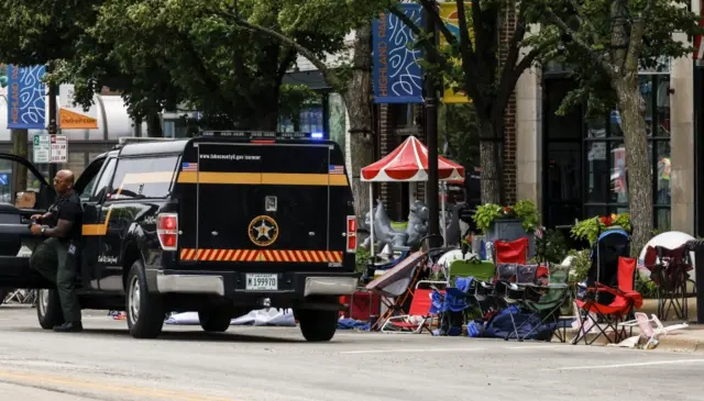 Chairs lie abandoned as law enforcement officers investigate the scene of a mass shooting at a 4th of July celebration and parade in Highland Park, Illinois, USA, 04 July 2022