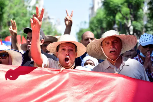 Protesters chant slogans while gesturing during a march in protest against the Tunisian President Kais Saied