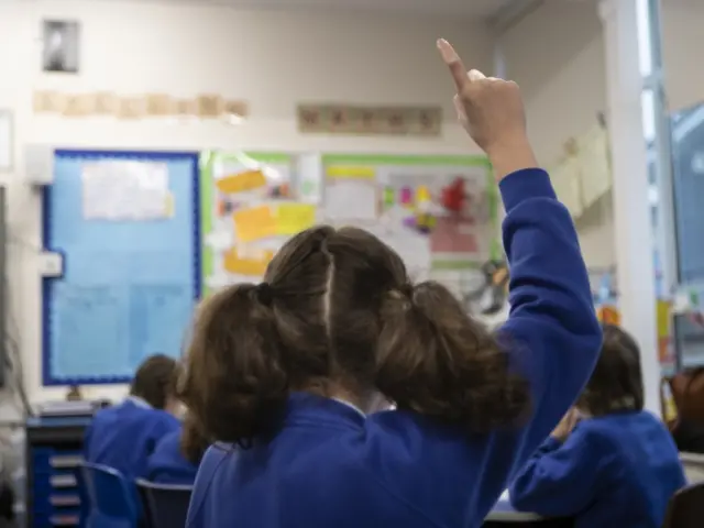 Child in class with hand up