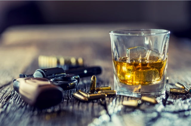 Glass of whisky and gun