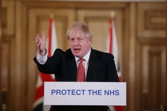 Boris Johnson at a lectern in Downing Street with the slogan Protect the NHS written on it