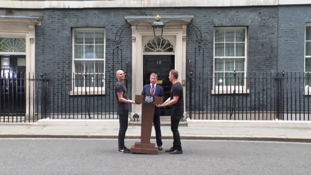 Downing Street staff bring out the podium where Boris Johnson will make his resignation speech