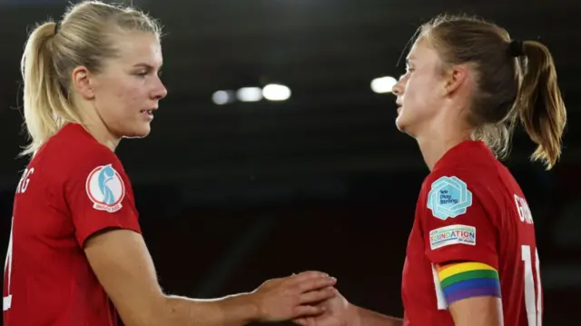 A photo of Hegerberg and Graham Hansen shaking hands
