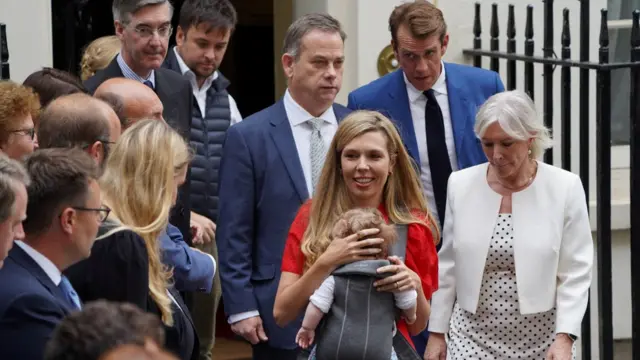 Carrie Johnson carries her baby as she walks next to Nadine Dorries on Downing Street