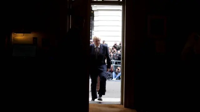 Prime Minister Boris Johnson walks back through the No 10 door after delivering his statement
