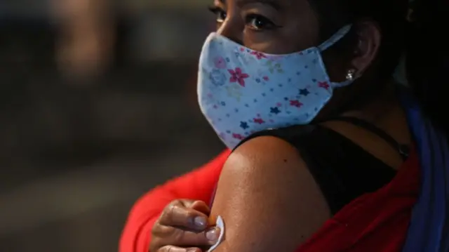 A woman holds a gauze after being vaccinated